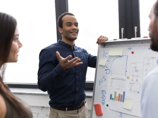 Team meeting with whiteboard statistics