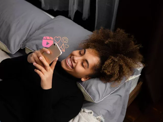 Woman laying down interacting with her phone