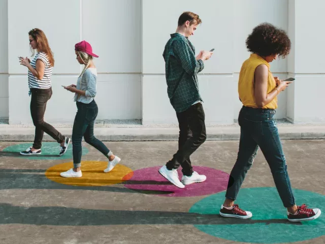 Young diverse crowd looking at their smartphones
